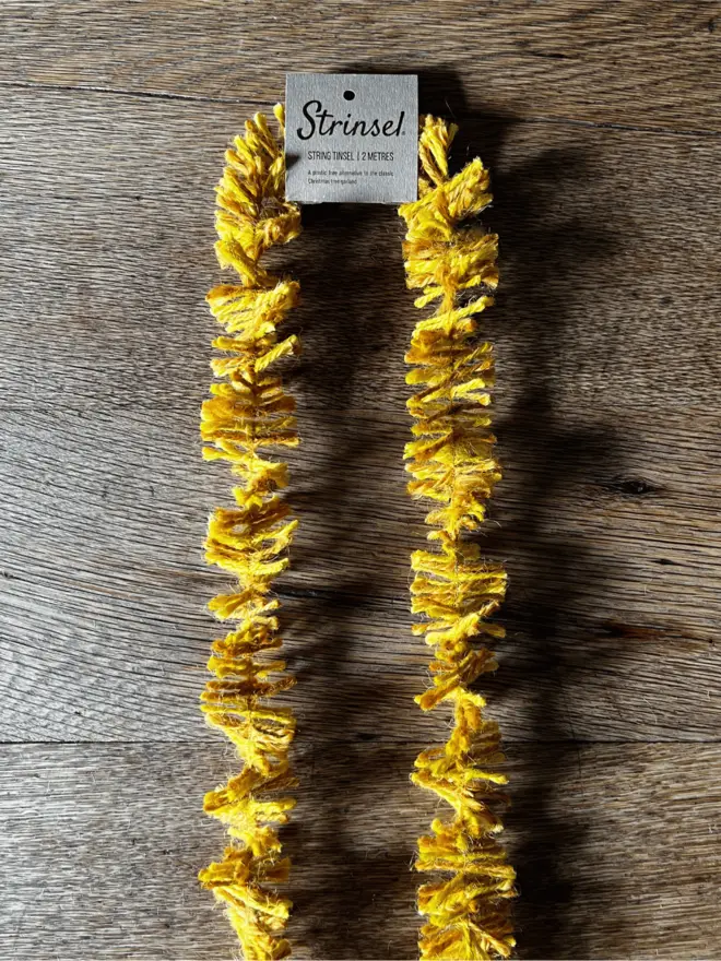 Classic Gold Strinsel AKA Jute string tinsel on an oak table