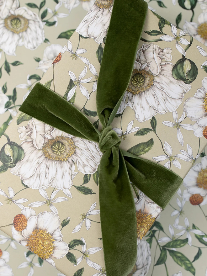 spring blossom floral gift wrap sheet. a box wrapped in pale green illustrated floral gift wrap with a green ribbon.