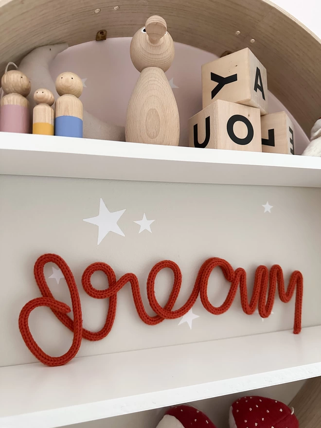 Kid's room decor, 'dream' wall hanging word decorating a child's playroom on a shelf. 