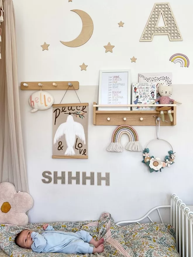 A pretty, neutral girls bedroom with a solid wood pegrail bookshelf 