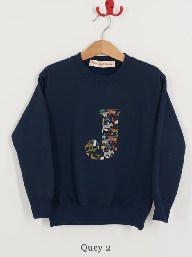 a kids navy sweatshirt with the initial J personalised in zoo animal liberty print on the front