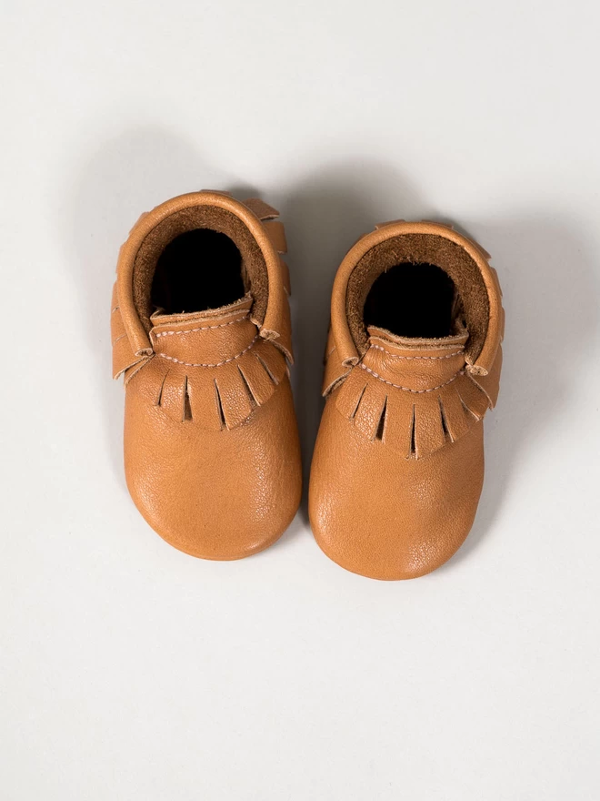 Classic tan colour Amy and Ivor baby moccasins with fringed ankle detail