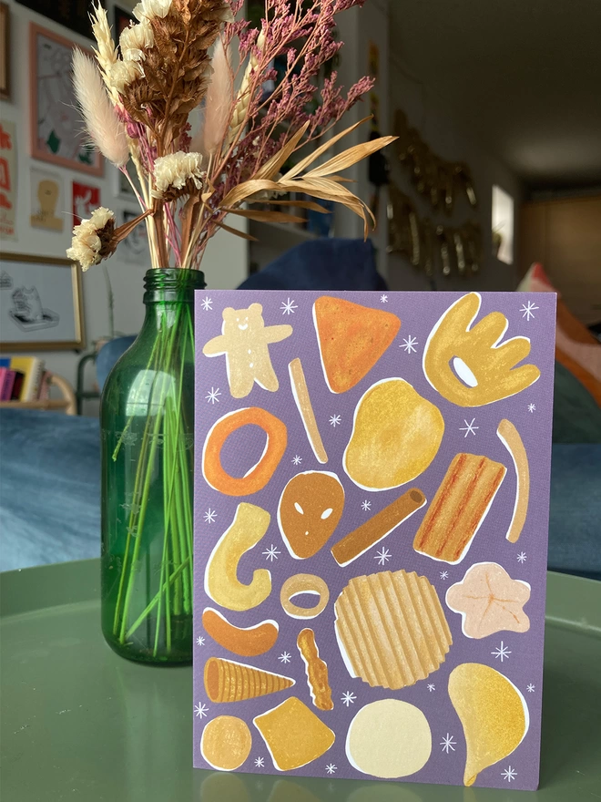 Crisps greetings card on table, with flowers in the background