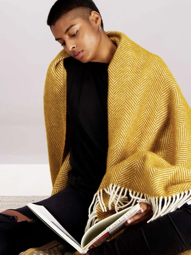 Organic Wool Throw, a person with the wool throw draped over them. 