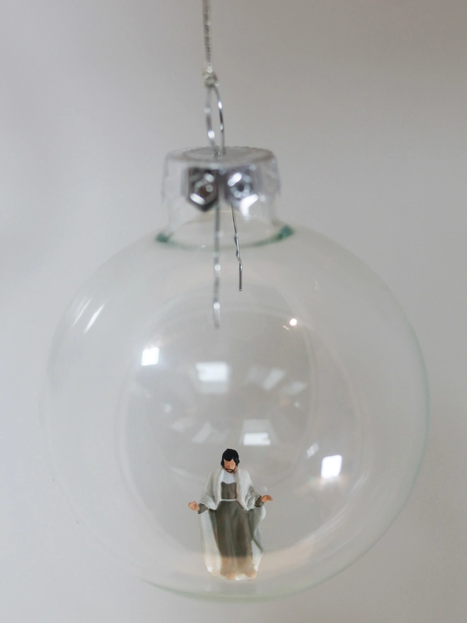 Miniature figure of Jesus in a glass Christmas bauble