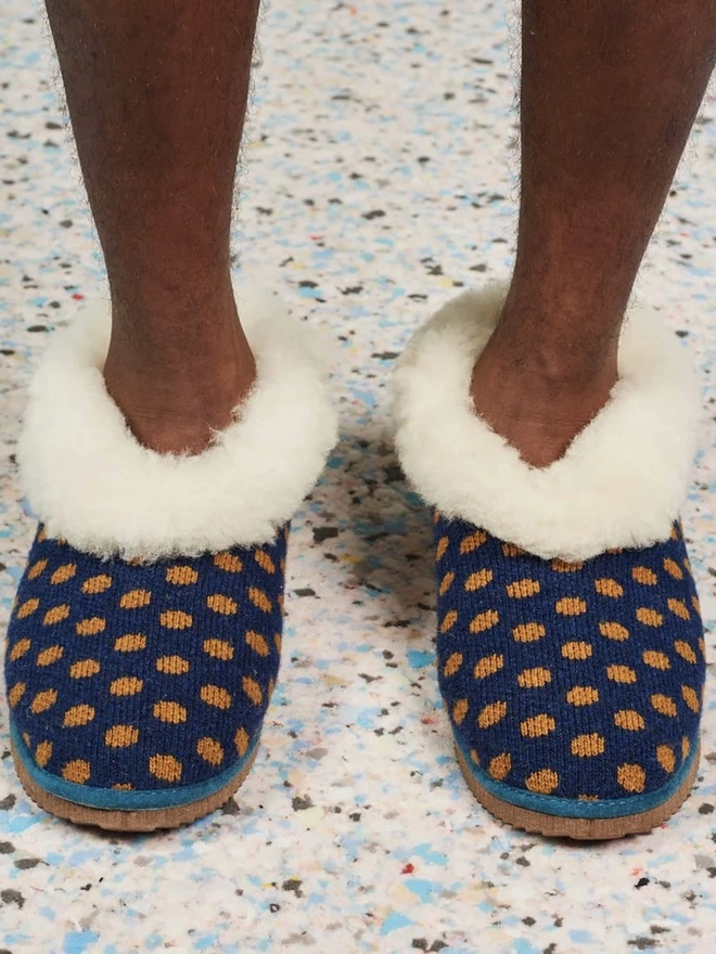 Lambswool & Sheepskin Slippers, a person wearing a pair of colourful lambswool and sheepskin slippers. 