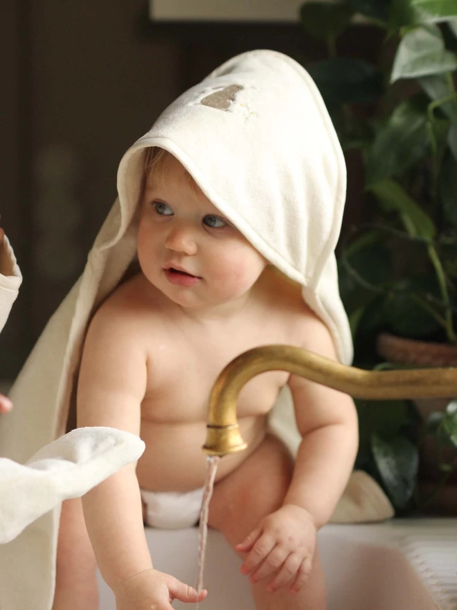Hooded towel baby worn by a baby on bath time