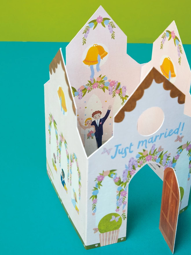 The church card has a die cut door that folds out to reveal the intricate design of inside the church where we can see the happy couple and guests celebrating their big day