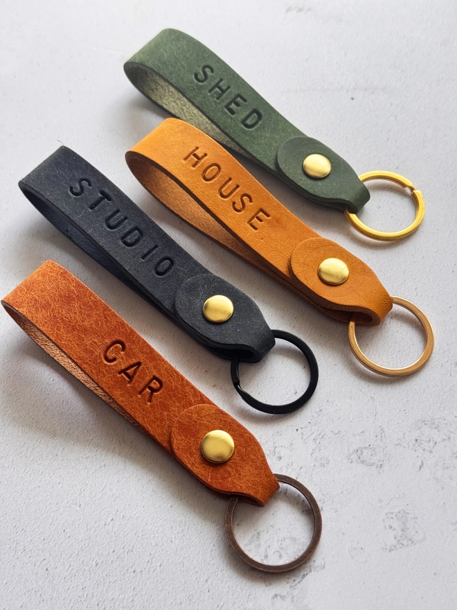 A selection of handmade leather keyrings personalised with a short word 