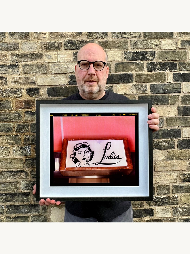 Richard holding Ladies Colour Typography Photograph framed in black
