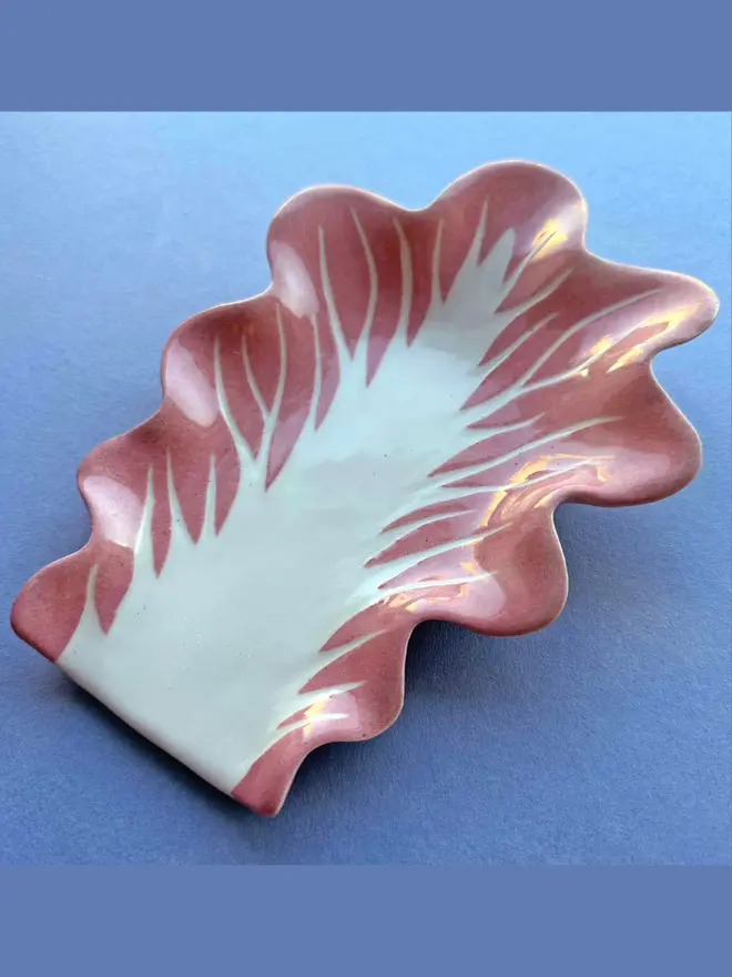 Radicchio Leaf Spoon Rest in Pink Radicchio on a plain blue background