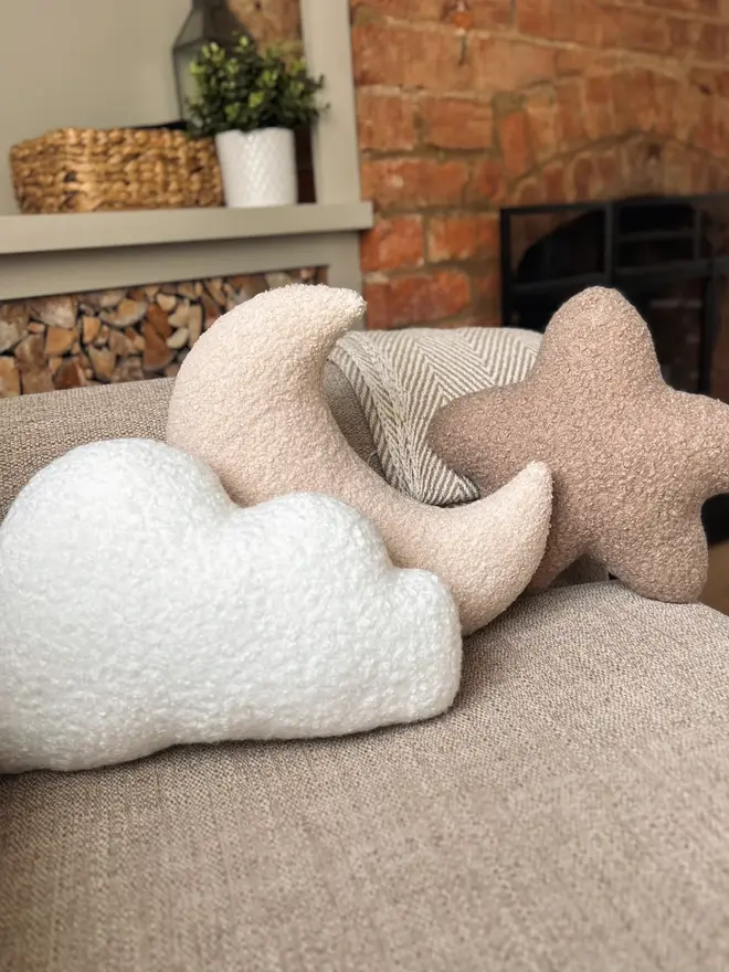 boucle moon star and cloud trio. cloud, star and moon shaped cushions on a sofa.