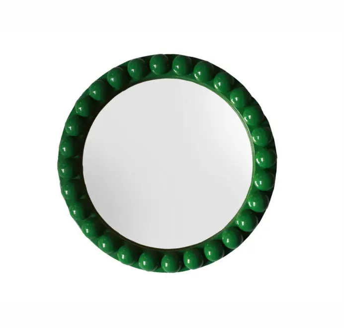 Round oversized bobbin mirror with a decorative bobbin-style wooden frame, hanging on a white wall.