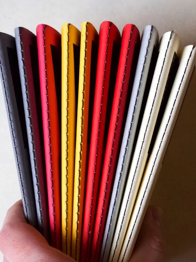 Notebook spine view in grey, red, yellow, pink, blue and white