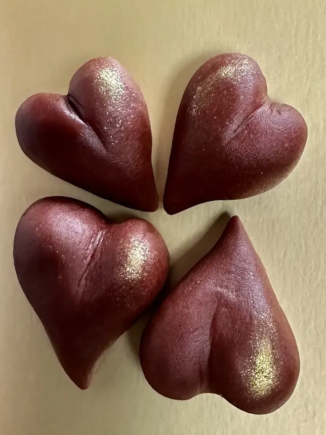 Marzihearts Valentines Chocolates (Box Of 6, 9, 12), chocolate valentines hearts grouped together above a yellow surface. 