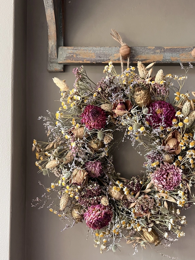 Autumnal dried flower wreath hung on kitchen wall 