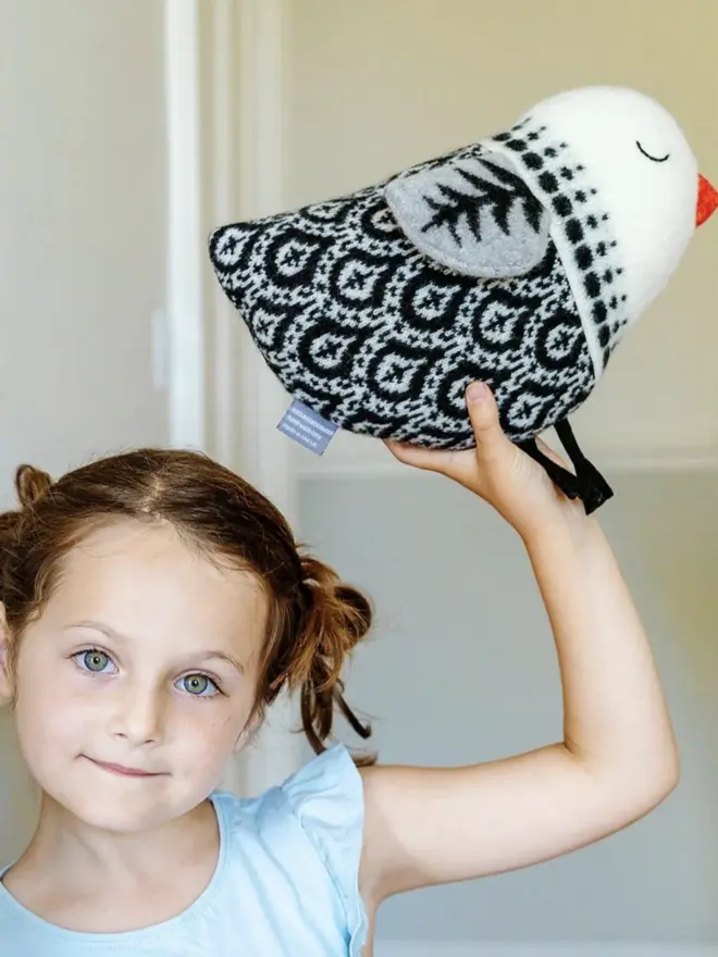 little girl holding a black bird plush