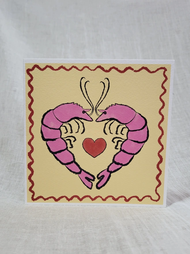 Pale yellow ground with pink prawns facing a red love heart