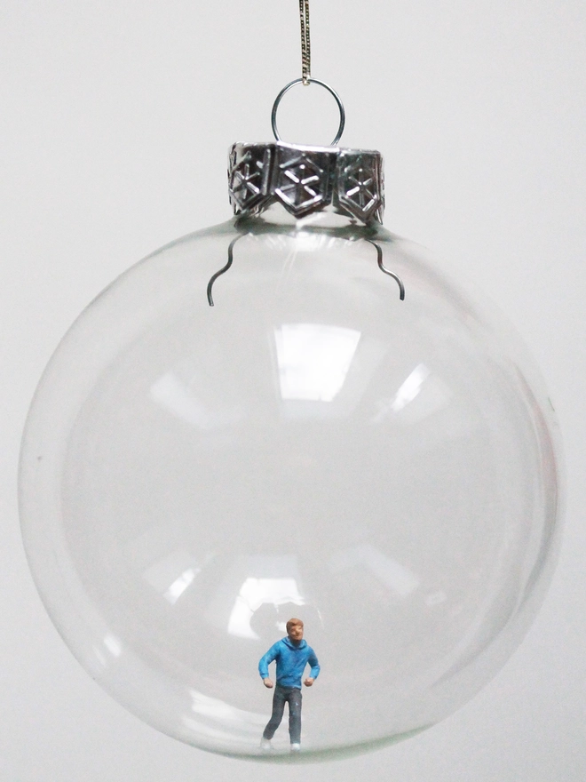 Miniature figure of a female runner in a glass Christmas bauble 