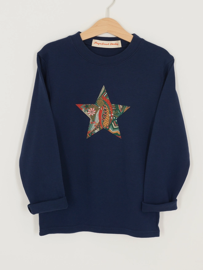  a navy blue christmas tee with a Liberty star print star sewn on the front