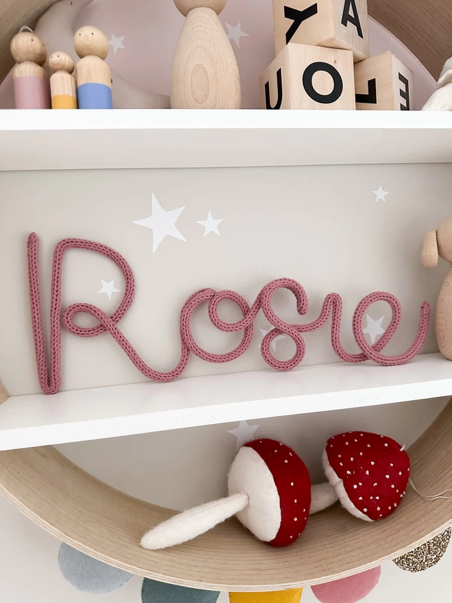 Personalised wall sign for kids - "Rosie" name sign on a shelf.