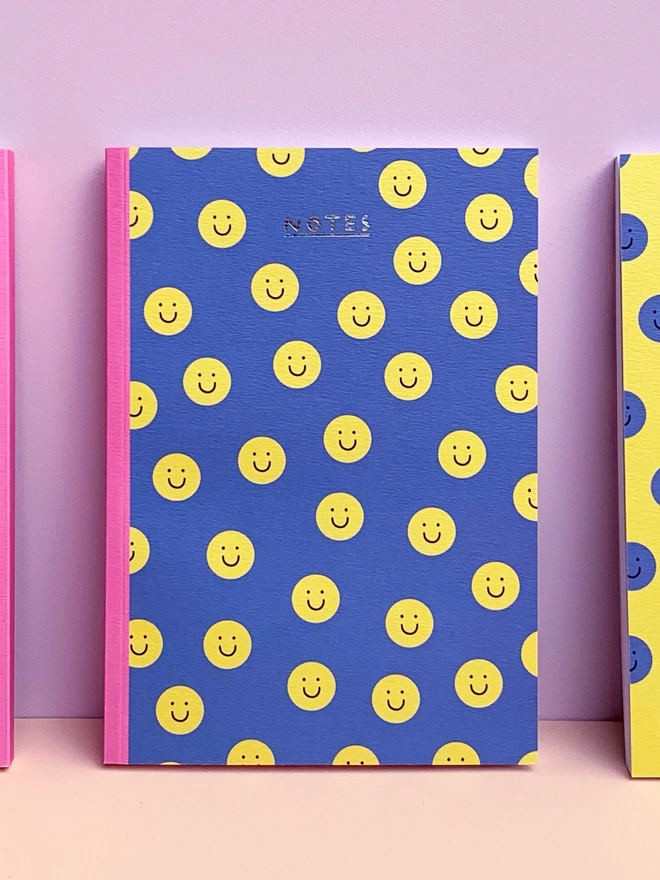 blue smiley face illustrated notebook