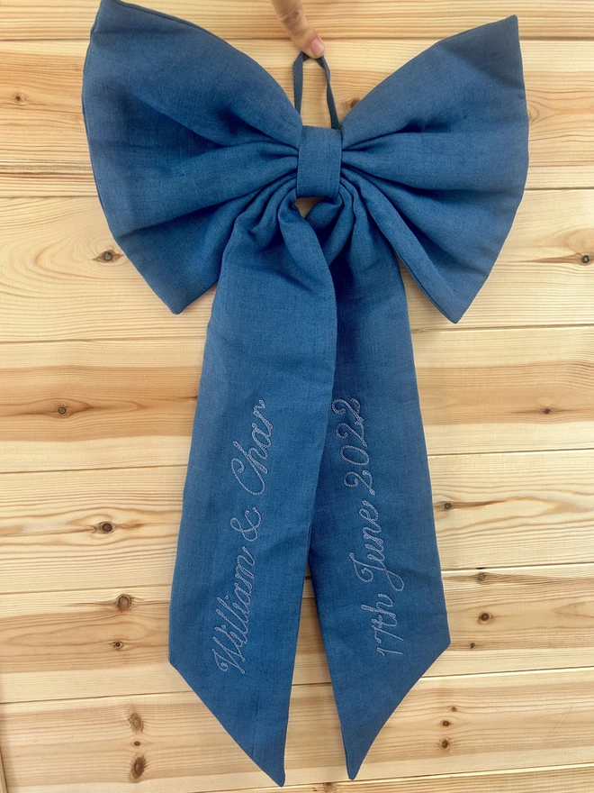 linen blue bow with blue embroidered writing