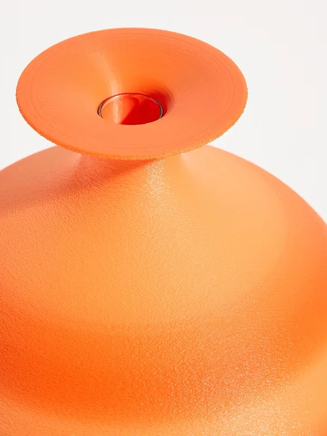 top of bright orange 3d printed vase