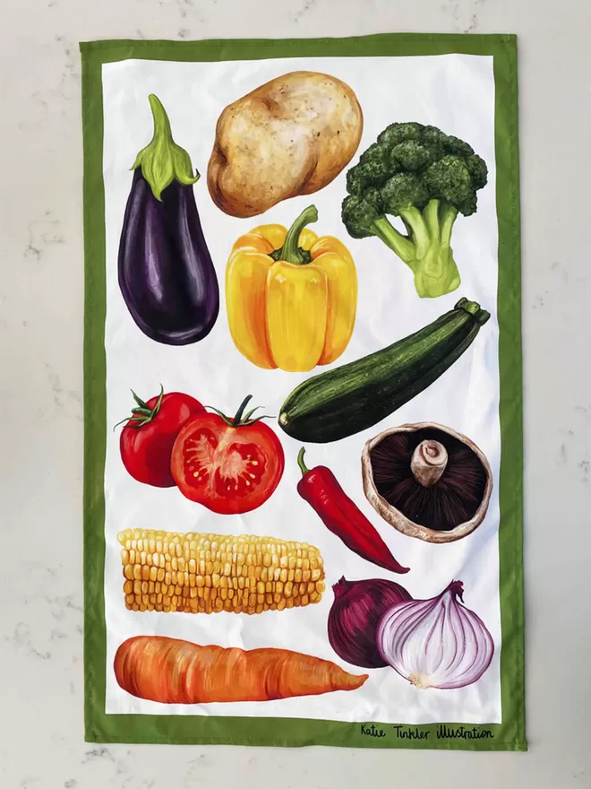 A vegetable themed tea towel laid out flat showing the design