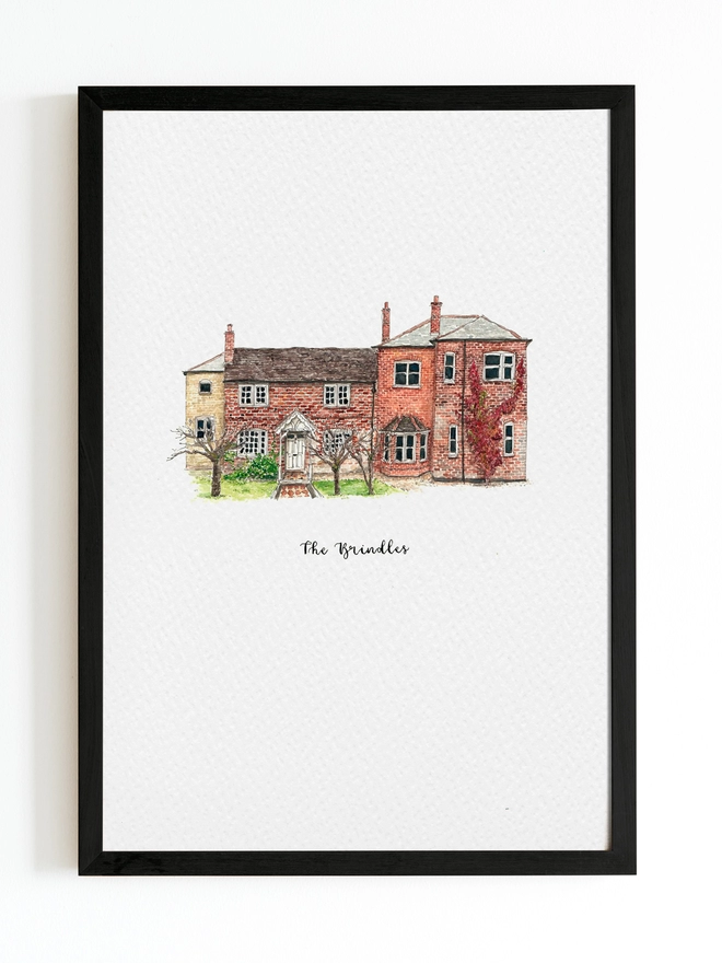 Black frame with white page inside and a beautiful mixed historic style house in the centre painted in intricate watercolour details. Below black calligraphy lettering reads The Brindles