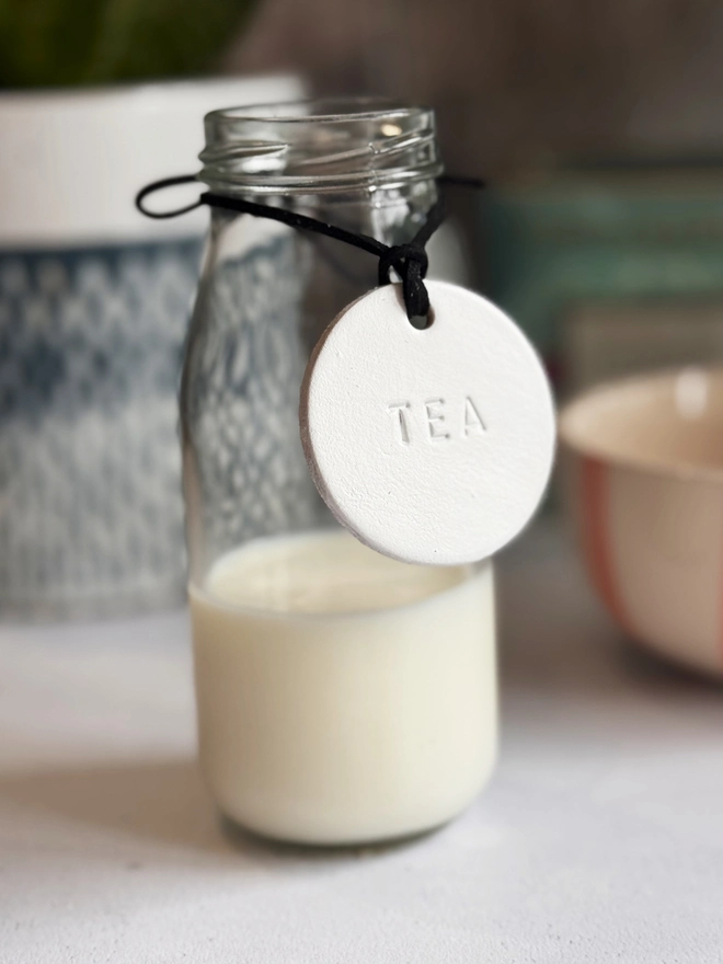 Minimalist white leather pantry tags with hand-stamped labels for kitchen storage. Rustic and stylish labels with black cord, ideal for home organisation and pantry décor.