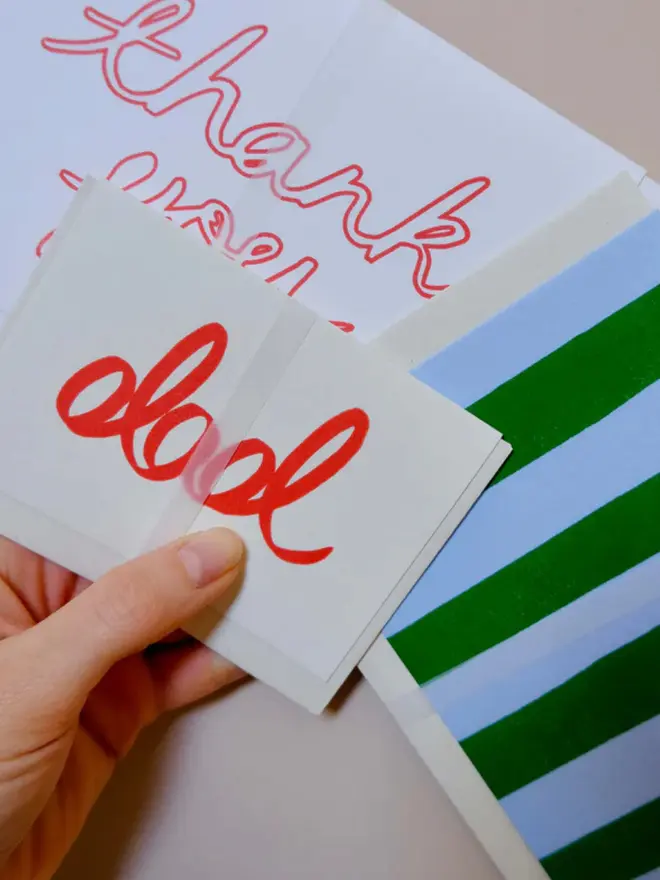 'Dad' hand printed in red on a white card, displayed on a table. 
