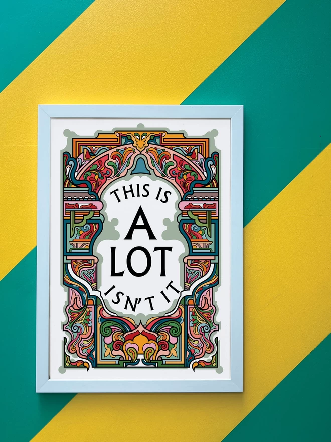 This is A Lot, Isn’t it is written in black on a white background at the centre of this bold, symmetrical portrait illustration. The picture is hanging in a white portrait frame against a wall painted with thick diagonal green and yellow stripes.