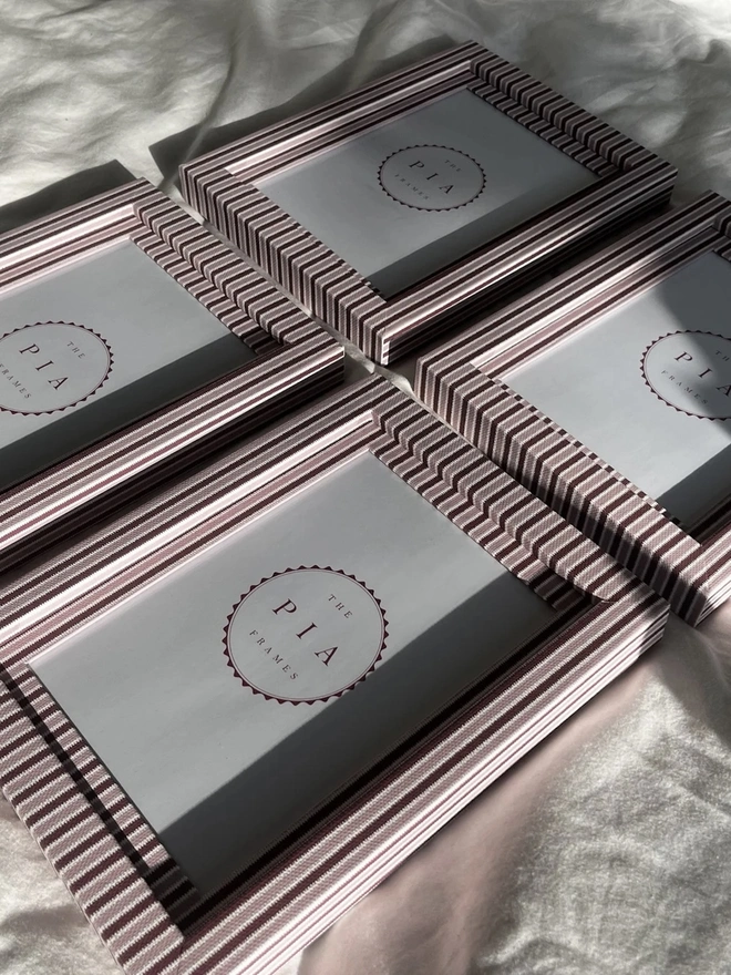 Blush & Burgundy Zigzag Frame, a  group of colourful striped frames sitting on a plain white surface. 