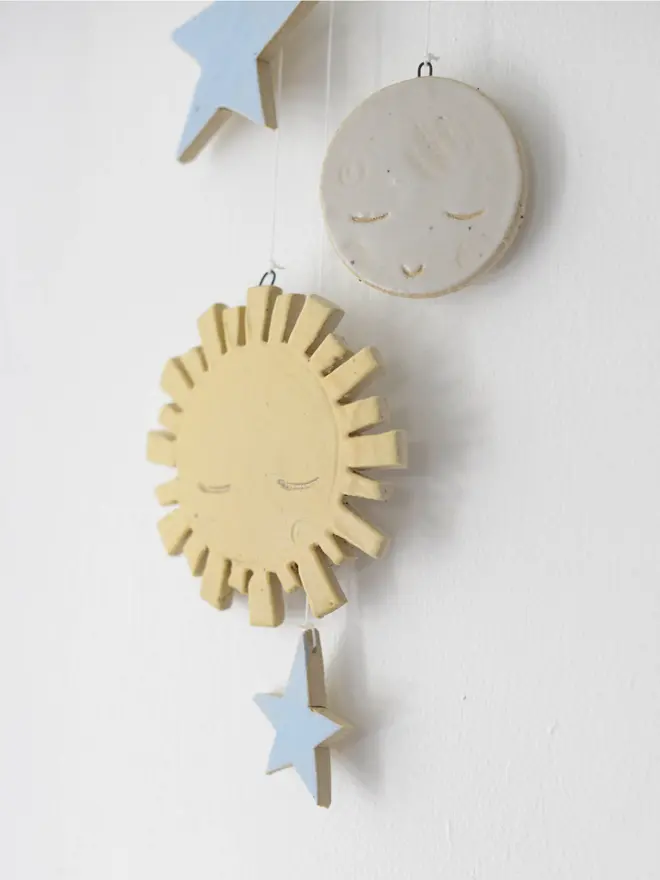 Close up of sun, moon and stars decorations on baby cot hanging