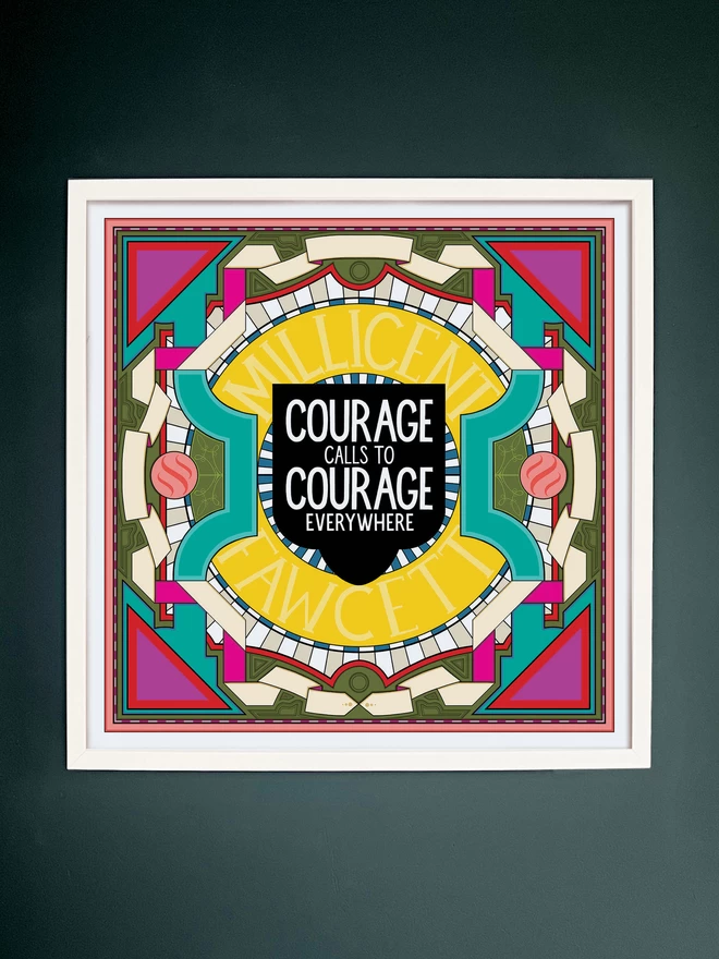 A square illustration with “Courage calls to courage everywhere” written in white against a black background at the centre, surrounded by Millicent Fawcett written in yellow, and bordered with a symmetrical design in white, greens and pinks. The picture is hanging in a white square frame on a dark grey wall.  