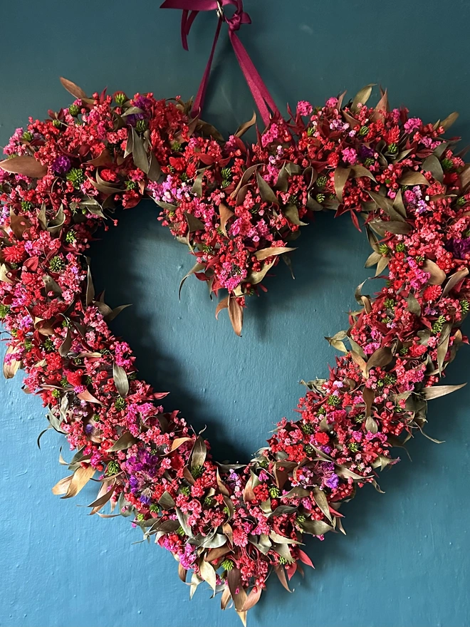 Heart shaped dried flower wreath. Dried red flowers arranged in a heart shape and made into a wreath.