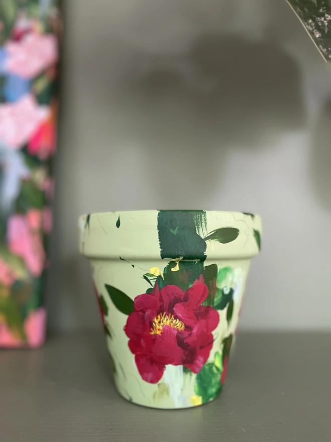 Hand painted pale green plant pot with deep red peonies