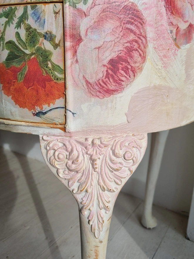 An antique kidney-shaped dressing table with chair and a trio of mirrors. Upcycled in cream and pale pink with decoupage florals in oranges and pinks. Text across the table read ‘flowers make me happy’ in the orange of the undercoat.