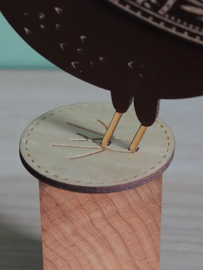 Standing Wooden Female Blackbird, black wooden bird standing on  a wooden platform. 