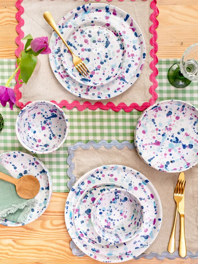 Sweetpea Dinner Plate, a colourful dinner plate placed on a colourful table accompanied by other ceramics. 