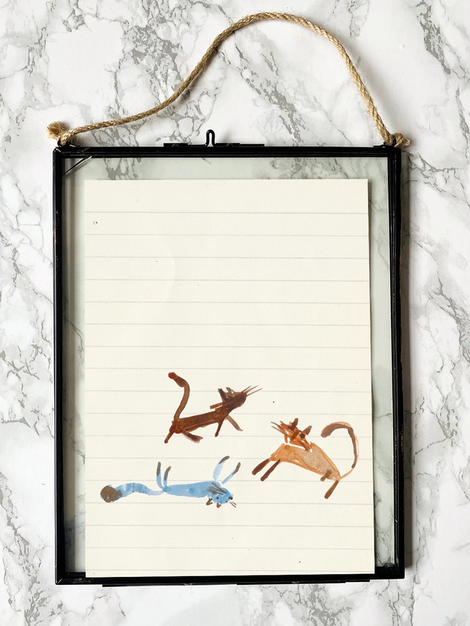 drawing of three cats in brown and blue tones in a frame