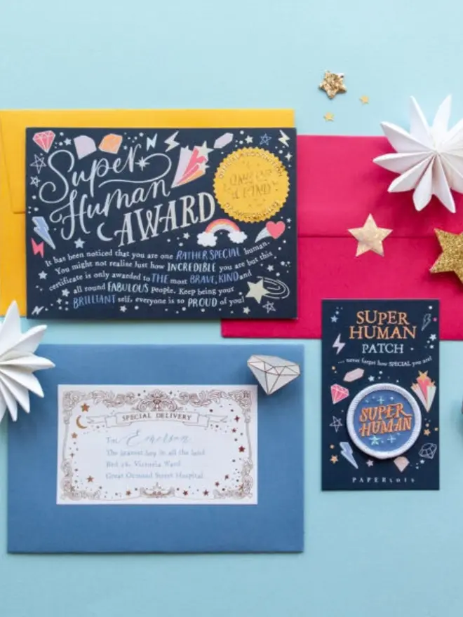 The award certificate on yellow and pink envelopes, next to the patch card. A blue envelope has a gold foil "Special Delivery" label addressed to Emerson, "the bravest boy in all the land."
