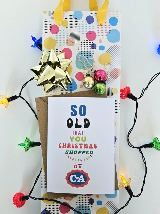 A photograph of the front of a humorous A6 greeting card illustrated using brightly coloured text and the retro shop logo. The text says so old you Christmas shopped at C&A