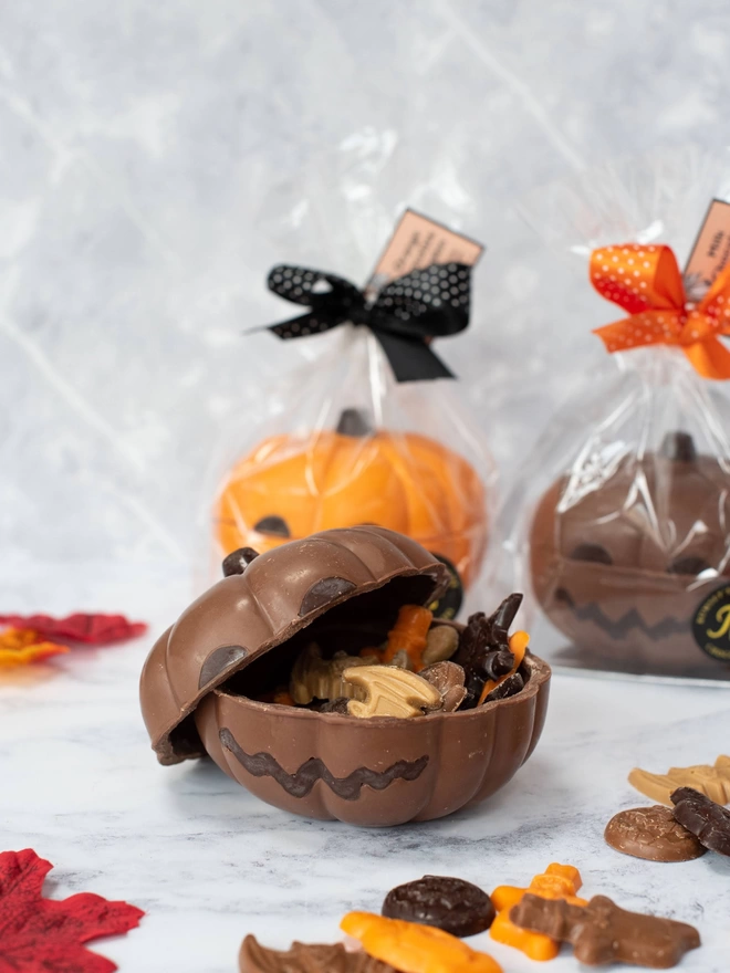 Open chocolate pumpkin with assorted halloween chocolate shapes