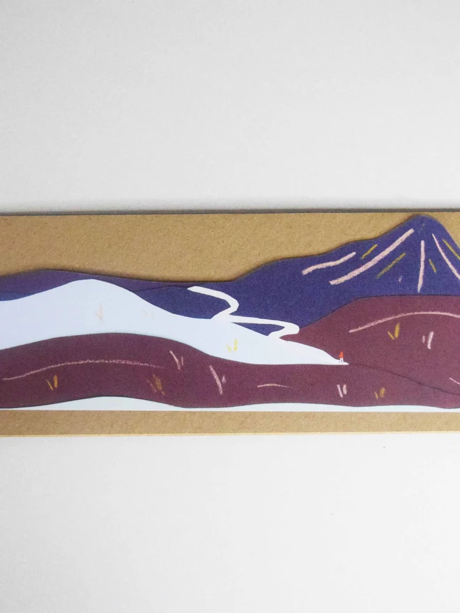 A cut out card of a mountain on top of an envelope