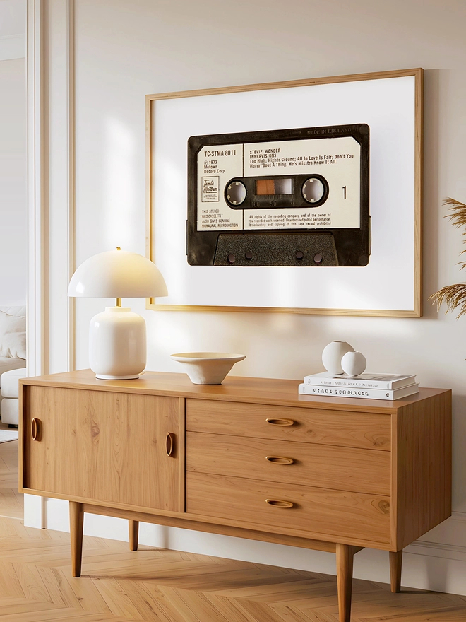 stevie wonder innervisions cassette tape print. framed print hung above wooden dresser.