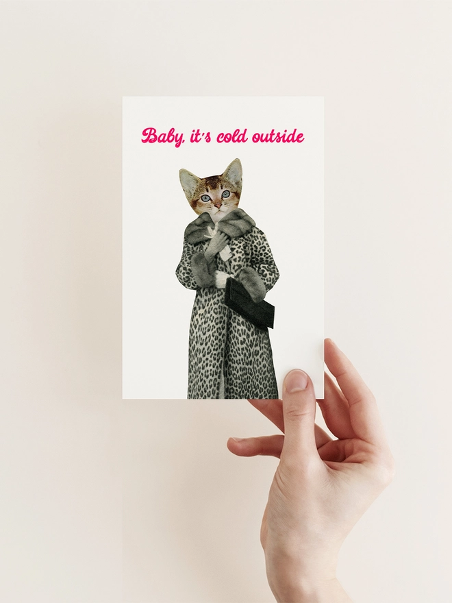 A funny Christmas card featuring a cat wearing a leopard print coat.