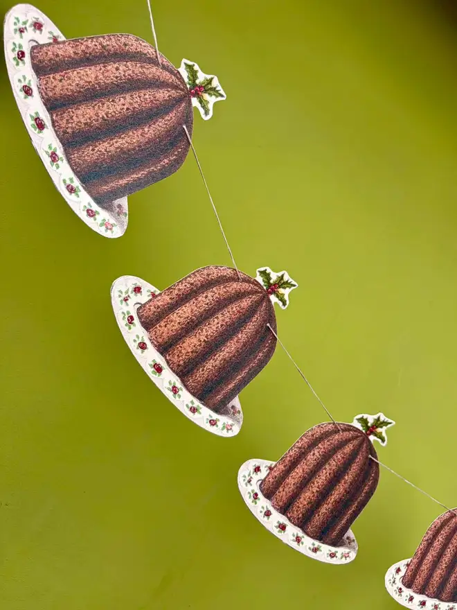 Paper cut out Christmas puddings strung as bunting