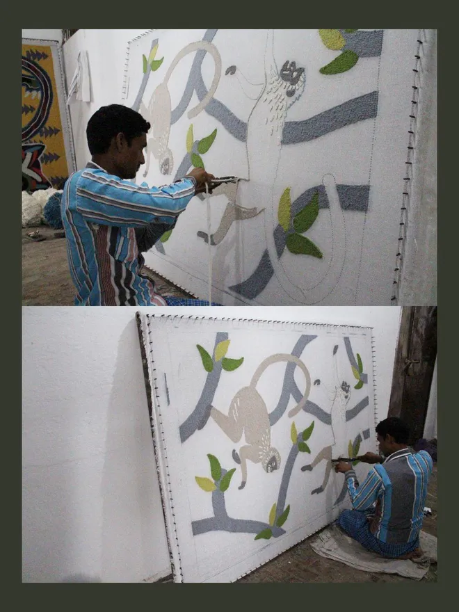 A person punching yarns through backing cloth to create a Langur monkey hand tufted rug.